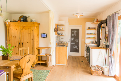 Interni luminosi e accoglienti del glamping SONNENTOR Lofts Oostenrijk, cucina in legno e arredi rustici.