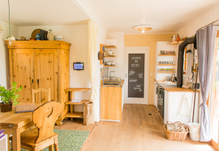 Cocina acogedora de alojamiento glamping SONNENTOR Lofts Oostenrijk con muebles de madera y luz natural.