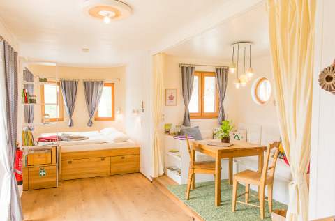 Bright and cozy glamping accommodation at SONNENTOR - Lofts Oostenrijk with bed, dining area and sitting nook.