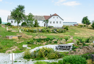 Glamping accommodation SONNENTOR - Lofts Oostenrijk with scenic green landscape and charming farmhouse view.