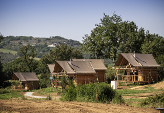 Glamourøse telte og hytter blandt træer på Camping Huttopia Pays de Cordes Sur Ciel i det franske Occitanië.