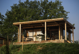Glamping accommodatie op Camping Huttopia Pays de Cordes Sur Ciel in Occitanië, houten chalet met terras.