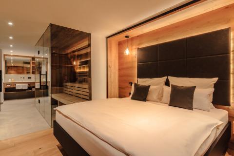 Chalet spa di lusso al Wirthshof Resort sul Lago di Costanza, camera moderna con parete di vetro.