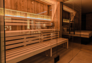 Innenansicht einer modernen Sauna im Spa Chalet Wirthshof Resort am Bodensee, mit Holz und Glaswänden.