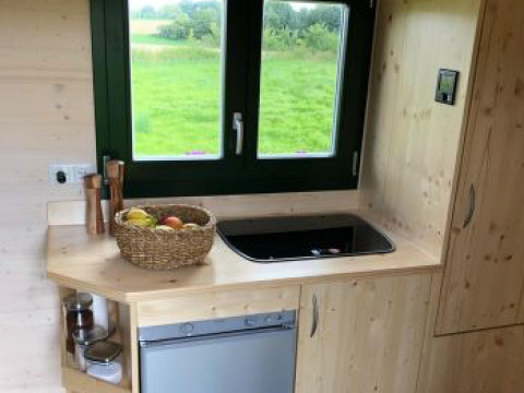 Keukenhoek in glamping Ferienhof Jeiler - Pipowagen Noordrijn Westfalen met uitzicht op groen landschap.