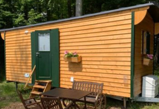 Ferienhof Jeiler - Pipowagen in Nordrhein-Westfalen, Glamping-Unterkunft mit Holzfassade und Outdoor-Tisch.