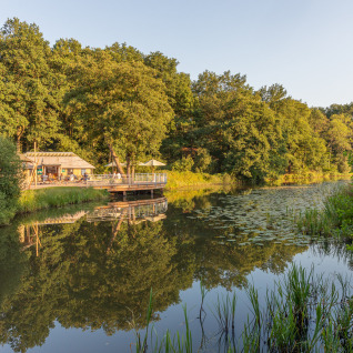 Glamping Camping Huttopia De Roos sulle rive del fiume Vecht in Overijssel, immerso nella natura verde.