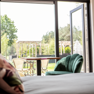 View from inside glamping accommodation at Landgoed Lindehof – Natuur Lodges Friesland to outdoor garden seating.
