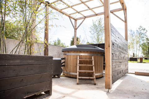 Buitenspa en terras bij Landgoed Lindehof – Natuur Lodges Friesland met houten details en overkapping.