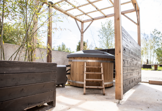 Buitenspa en terras bij Landgoed Lindehof – Natuur Lodges Friesland met houten accenten en overkapping.