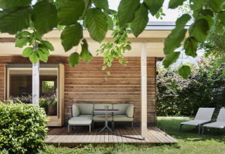 Moderne glamping lodge met houten gevel en terras bij Natuurlijk Hell Camping & Aparthotel Tuin Lodges Tirol.