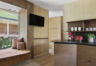 Moderne glamping lodge met houten interieur, vensterbank, flatscreen-tv en koffiezetapparaat bij Natürlich Hell.