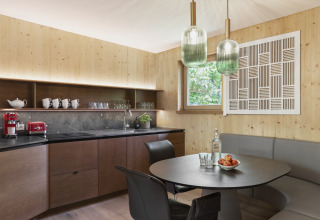 Moderne keuken en eetruimte in Natürlich Hell Camping & Aparthotel - Tuin Lodges Tirol met houten accenten.