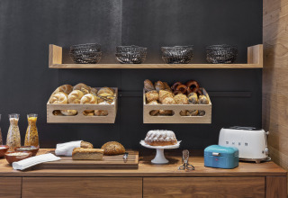 Frühstücksbuffet mit Brot, Toaster und Müsli-Gläsern bei Natürlich Hell Camping & Aparthotel in Tirol.