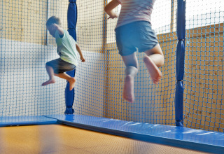 To børn hopper på trampolin i et legemiljø hos Natürlich Hell Camping & Aparthotel - Tuin Lodges Tirol.