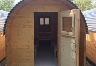 Houten glamping pod met open deur bij Camping Hegne - Luxe pods aan de Bodensee, in het groen.