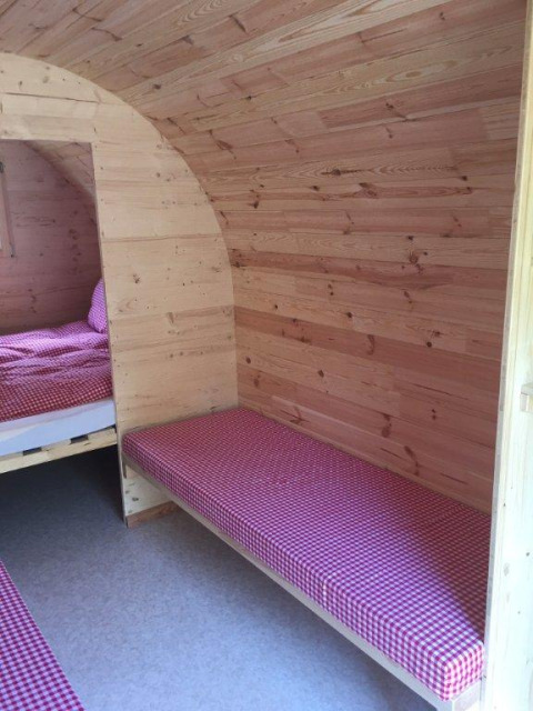 Interior view of luxury glamping pods at Camping Hegne by Lake Constance, featuring wooden walls and beds.