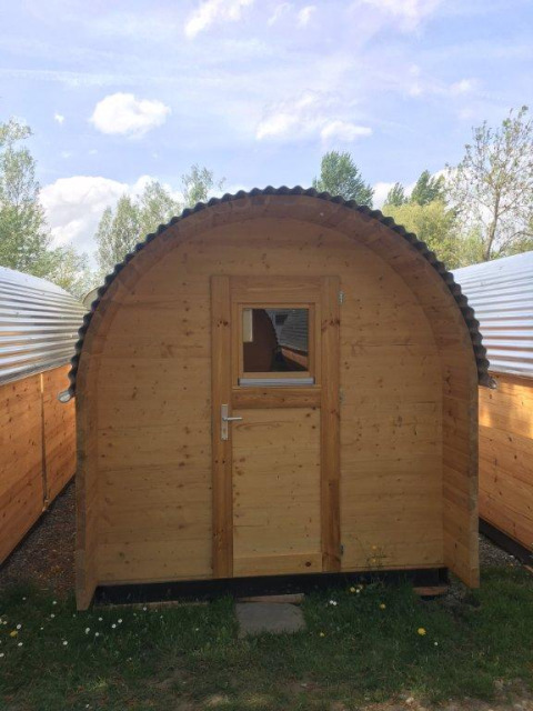 Houten glampingpod bij Camping Hegne aan de Bodensee, tussen andere luxe pods en groene omgeving.