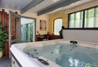 Area benessere interna con vasca idromassaggio e ampie finestre a Les Truffières de Dordogne – La Bouquerie – Safaritenten.