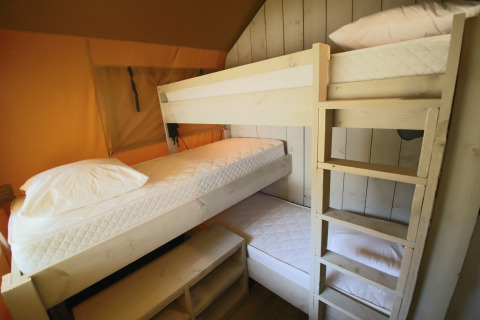 Interior view of glamping accommodation featuring bunk beds in Les Truffières de Dordogne’s safari tents.