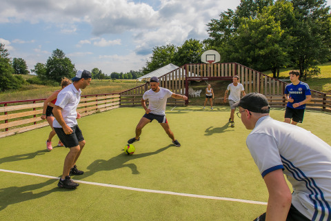 Des invités jouent au football sur un terrain à Les Truffières de Dordogne – La Bouquerie – Safaritenten Nouvelle-Aquitaine.