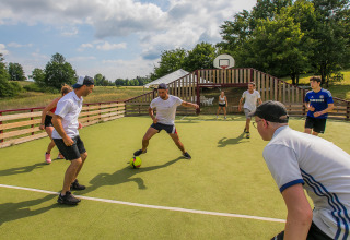 Gasten spelen voetbal op een veld bij Les Truffières de Dordogne – La Bouquerie – Safaritenten Nouvelle-Aquitaine.