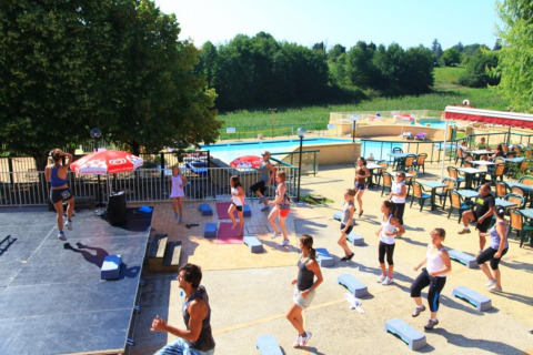 Lezione di fitness all’aperto vicino alla piscina a Les Truffières de Dordogne – La Bouquerie – Safaritenten Nouvelle-Aquitaine.