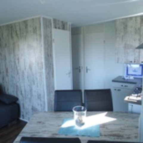 Interior view of a modern chalet at Camping Wackerballig, Schleswig-Holstein, featuring a dining table.