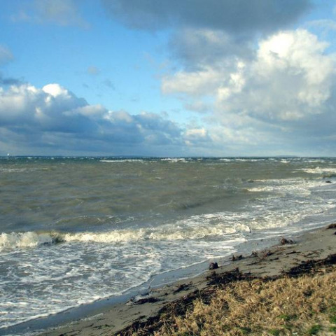 Vista costera en Camping Wackerballig con olas y nubes en Schleswig-Holstein, Alemania.