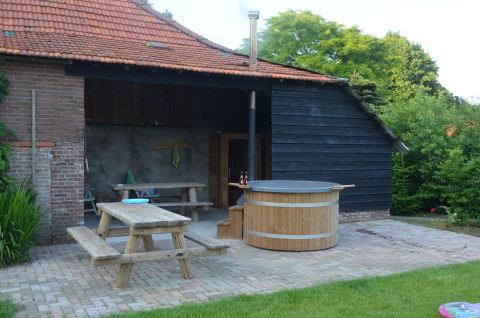 Udendørs område ved Glamping de Bosweide i Noord-Brabant med træbord, sauna og vildmarksbad.