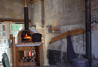 Horno de leña y decoración rústica en Glamping de Bosweide, Noord-Brabant, Países Bajos.