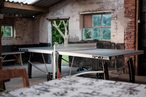 Table de ping-pong dans un espace commun rustique du Glamping de Bosweide, safaritenten Noord-Brabant.