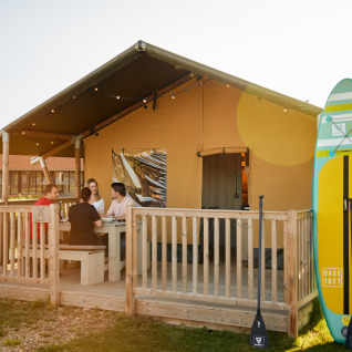 Tienda glamping en Erfgoedpark de Hoop, Noord-Holland, cuatro personas fuera, dos paddleboards al lado.