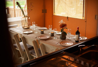 Tavolo elegante in una tenda glamping a Erfgoedpark de Hoop - Glampingtenten Noord-Holland con vino e fiori.