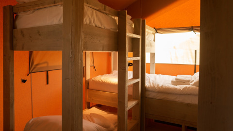 Interior of a glamping tent with bunk beds and natural light, Erfgoedpark de Hoop, Noord-Holland.