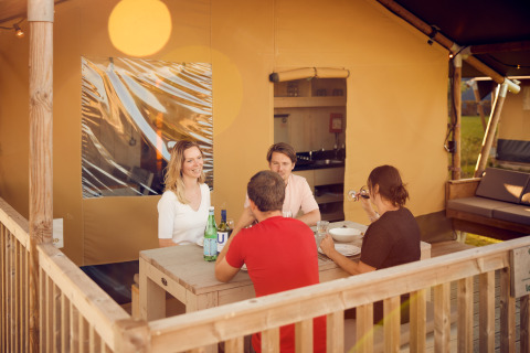 Cuatro personas cenando al aire libre en las tiendas glamping de Erfgoedpark de Hoop en Noord-Holland.