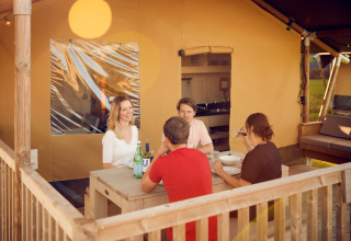 Cuatro personas cenando al aire libre en las tiendas glamping de Erfgoedpark de Hoop en Noord-Holland.