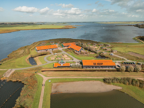 Luftfoto af Erfgoedpark de Hoop med glampingtelte og søudsigt i Noord-Holland, ideel til luksuriøs camping.