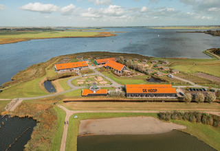 Vue aérienne de l'Erfgoedpark de Hoop avec ses tentes glamping et lac à Noord-Holland, pour un camping luxueux.