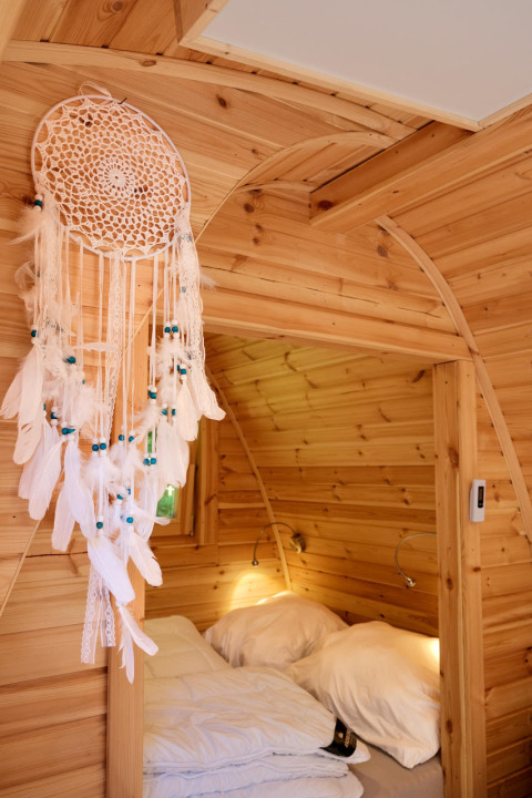 Hyggelig glampingindkvartering i træ med drømmefanger og dobbelt seng på Natuurpark Camping Prinzenholz.