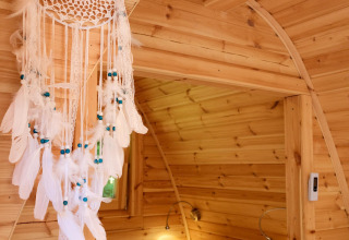 Gemütliche Glamping-Unterkunft mit Holzinterieur, Traumfänger und Doppelbett in Natuurpark Camping Prinzenholz.