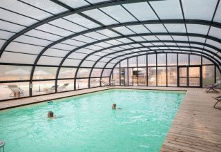 Indendørs swimmingpool med gennemsigtigt tag på Village Huttopia Forêt des Vosges glamping i Frankrig.