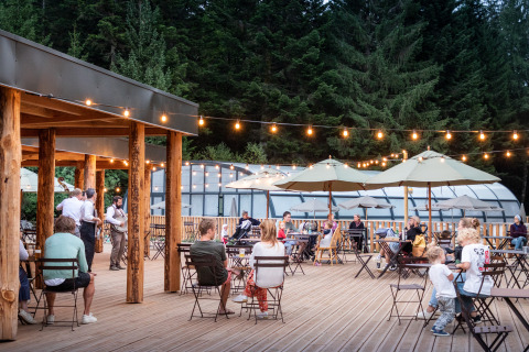 Espace extérieur animé avec clients et guirlandes au Village Huttopia Forêt des Vosges - Glamping Vogezen.