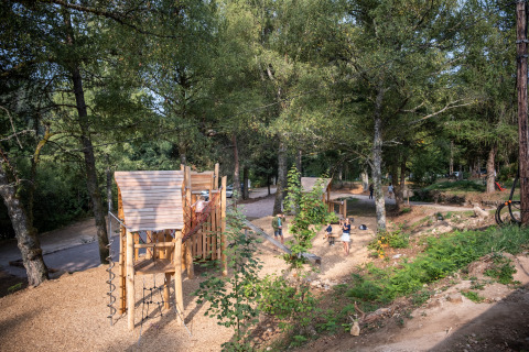 Aire de jeux en forêt au Village Huttopia Forêt des Vosges - Glamping Vogezen avec des enfants qui jouent.