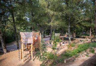 Área de juegos en el bosque en Village Huttopia Forêt des Vosges - Glamping Vogezen con niños jugando.