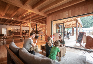 Gezin geniet samen in een knusse houten lodge bij Village Huttopia Forêt des Vosges - Glamping Vogezen.