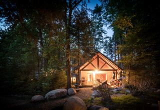 Suggestiva baita nei boschi al tramonto presso Village Huttopia Forêt des Vosges, esperienza glamping Vogezen.