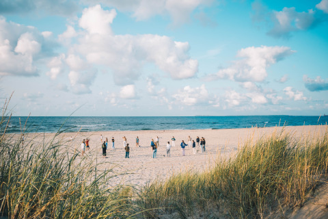Des personnes participent à une activité de groupe sur la plage à Surfana Family Camp Bloemendaal, Glamping Noord-Holland.