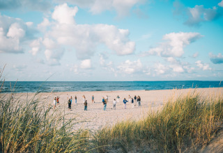 Personas participan en una actividad en la playa en Surfana Family Camp Bloemendaal, Glamping Noord-Holland.