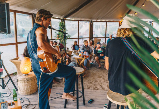 Acoustic music night at Surfana Family Camp Bloemendaal Glamping with relaxed guests enjoying music.
